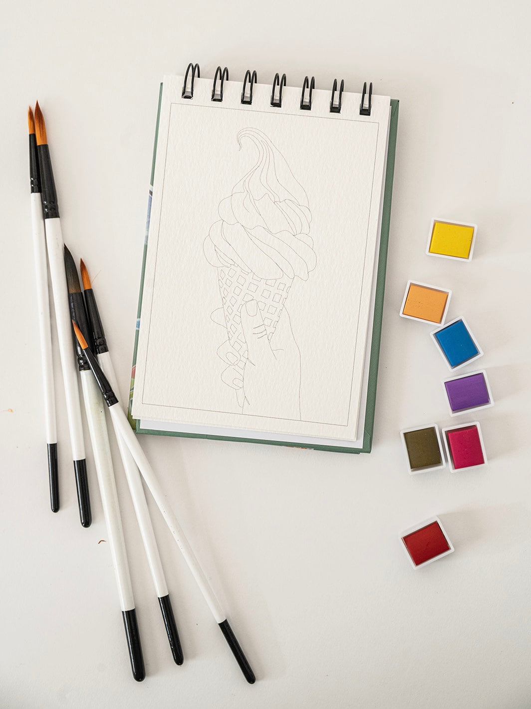 Set of watercolor brushes and color swatches on a white surface