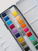 Set of watercolor paints in a metal case on a white background