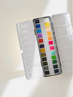 Watercolor palette with a variety of colors on a white background