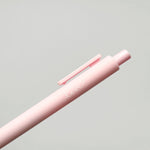 Pink pen with 'love' engraving on a light gray background