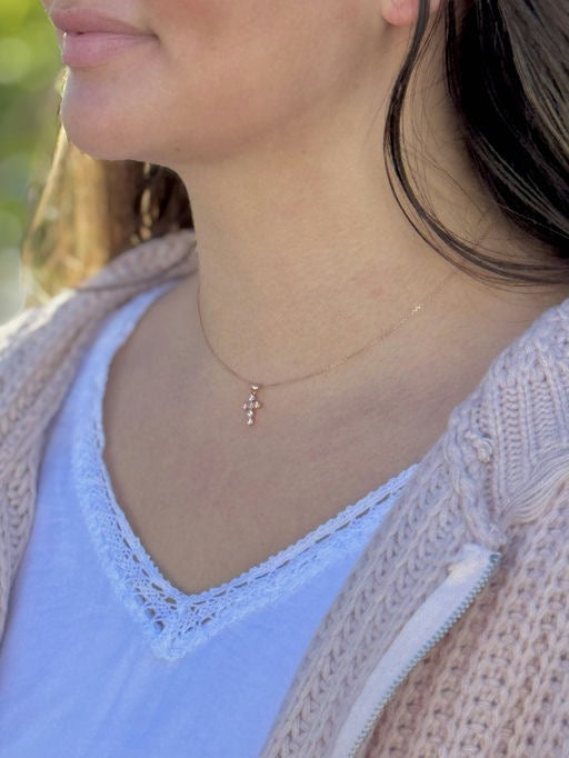 Close-up of a person wearing a delicate necklace with a blurred background