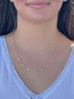 Person wearing a delicate gold and silver necklace