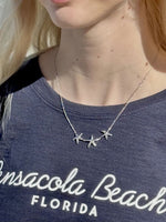 sterling silver starfish trio necklace worn with a crewneck top, showing length and placement.