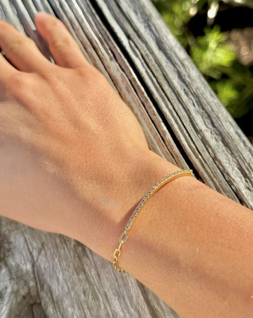 Model wearing a gold plated sterling silver bracelet with pavé bar detail, photographed outdoors on a wrist