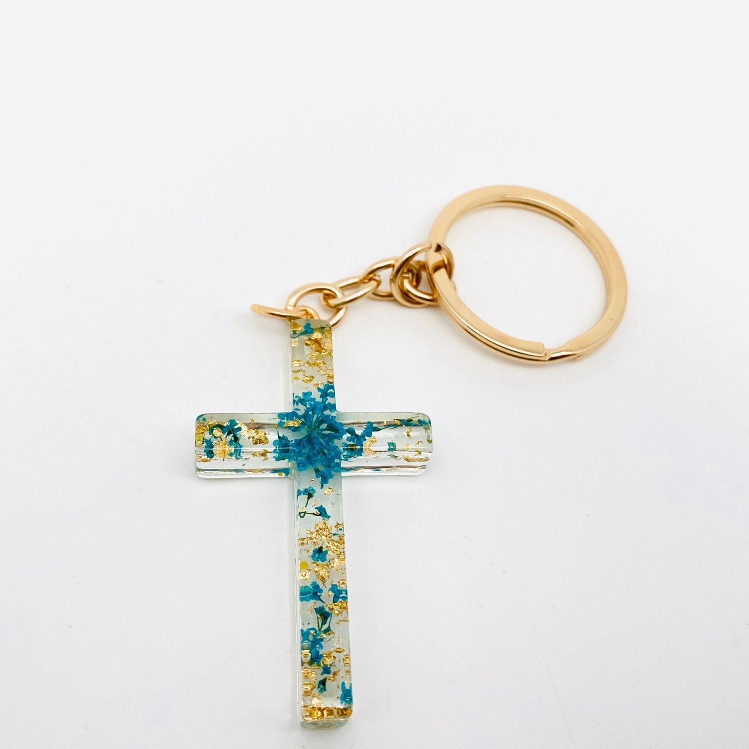 Cross-shaped keychain with floral design on a white background