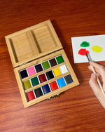 Wooden watercolor set with paint swatches on a wooden surface