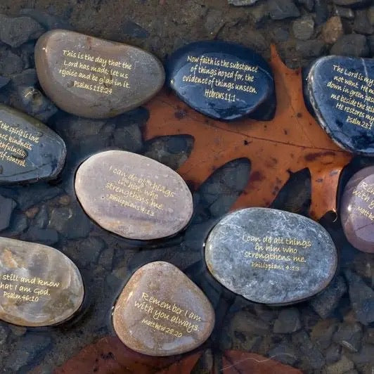 Decorative stones with engraved text on a rocky surface