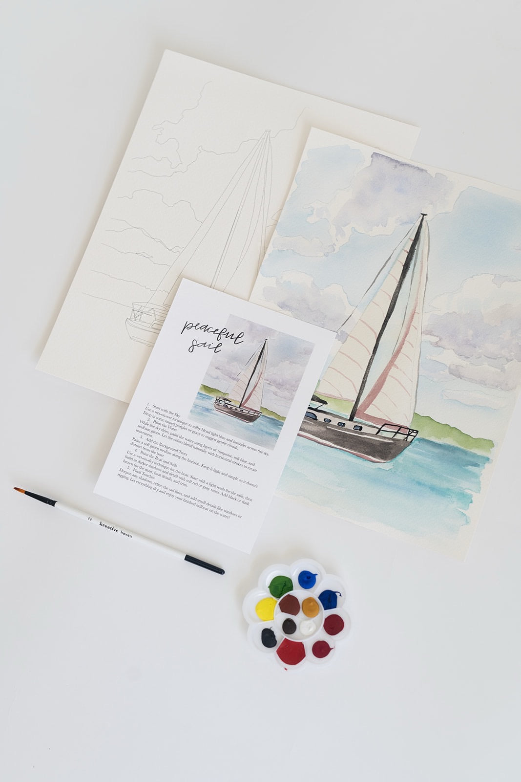 Peaceful Sail watercolor painting kit with sailboat artwork, outline sketch, brush, and paint palette on a white surface.”
