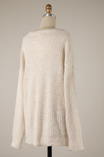 Beige textured sweater on a mannequin against a plain background