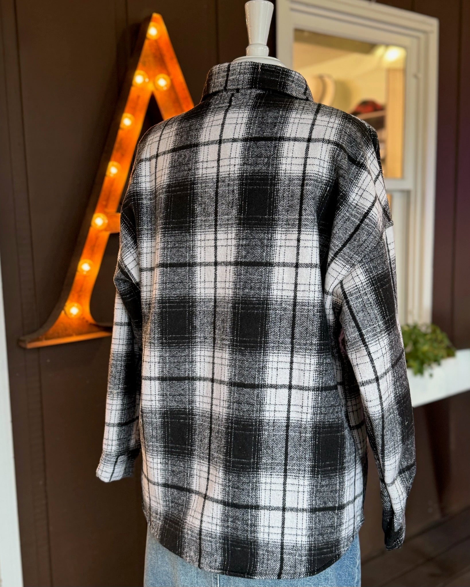 Back view of black and white plaid shacket showing relaxed fit and soft texture