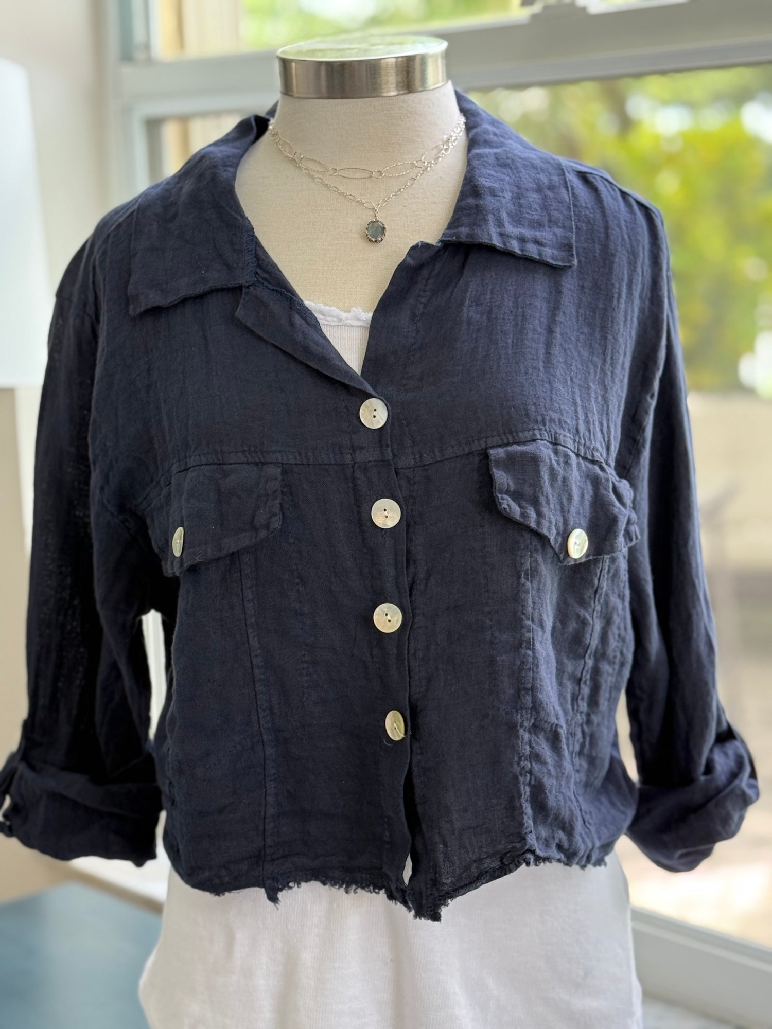 Navy linen jacket layered over basic white tank