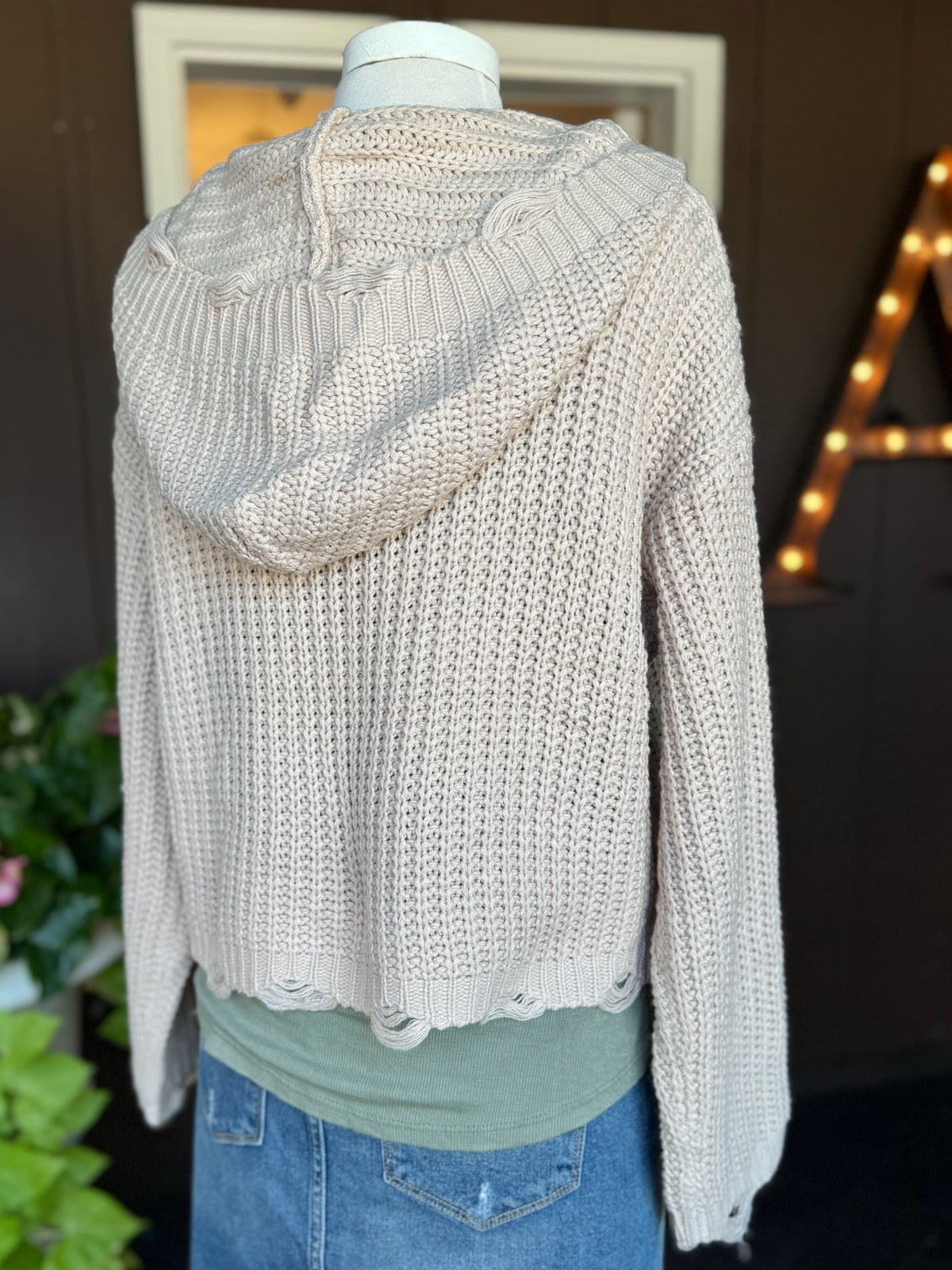 Back view of the Kennedy Hoodie in sandy beige featuring a soft textured knit, relaxed cropped fit, long sleeves, and knit hood at Ardor Boutique.