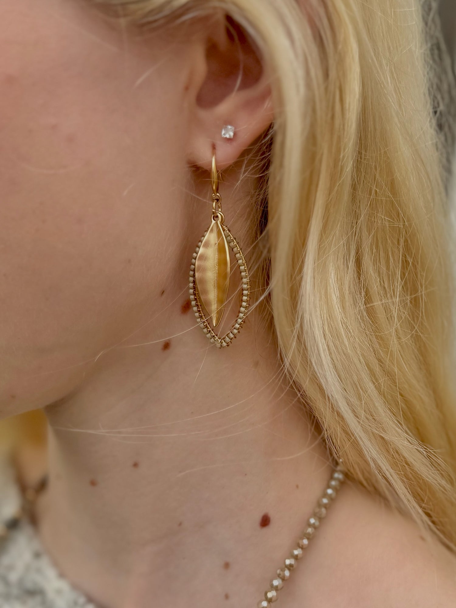 Lena Leaf Drop Earrings in matte gold shown on model