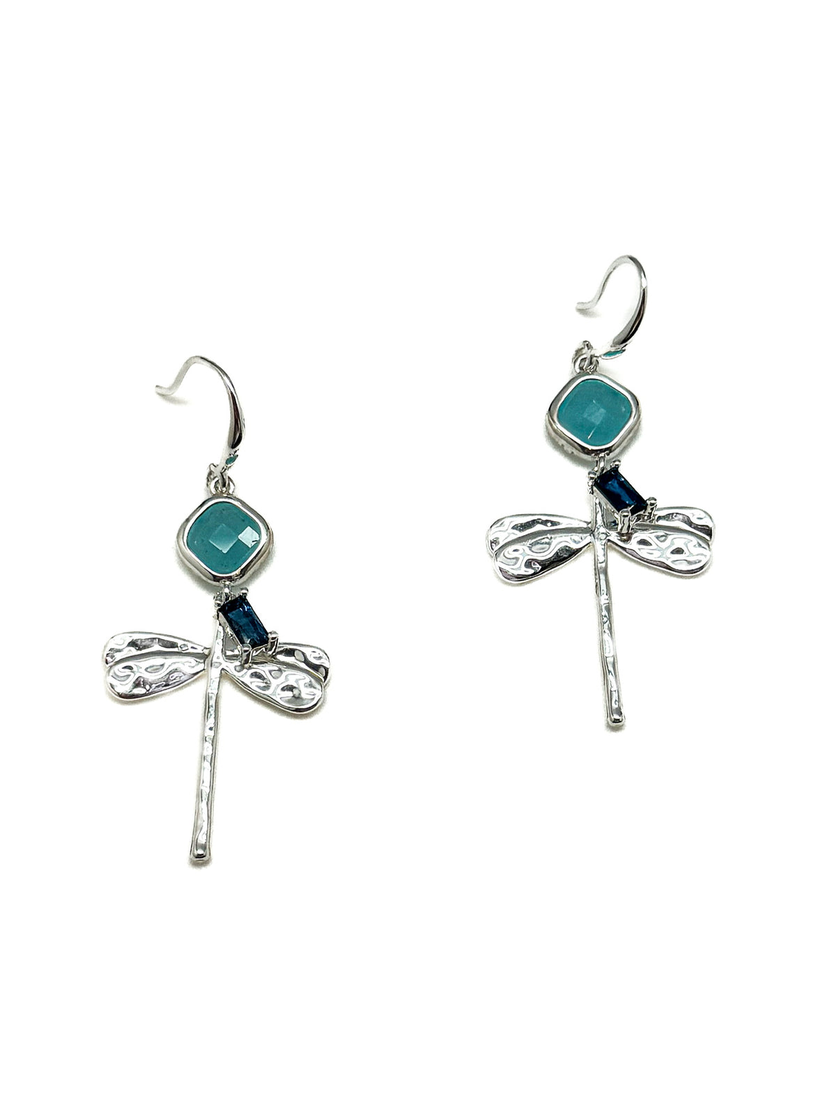 Woman wearing Lila Dragonfly Earrings in Silver, featuring textured silver dragonfly charms, turquoise-blue stones, and deep blue accents with fishhook closures.