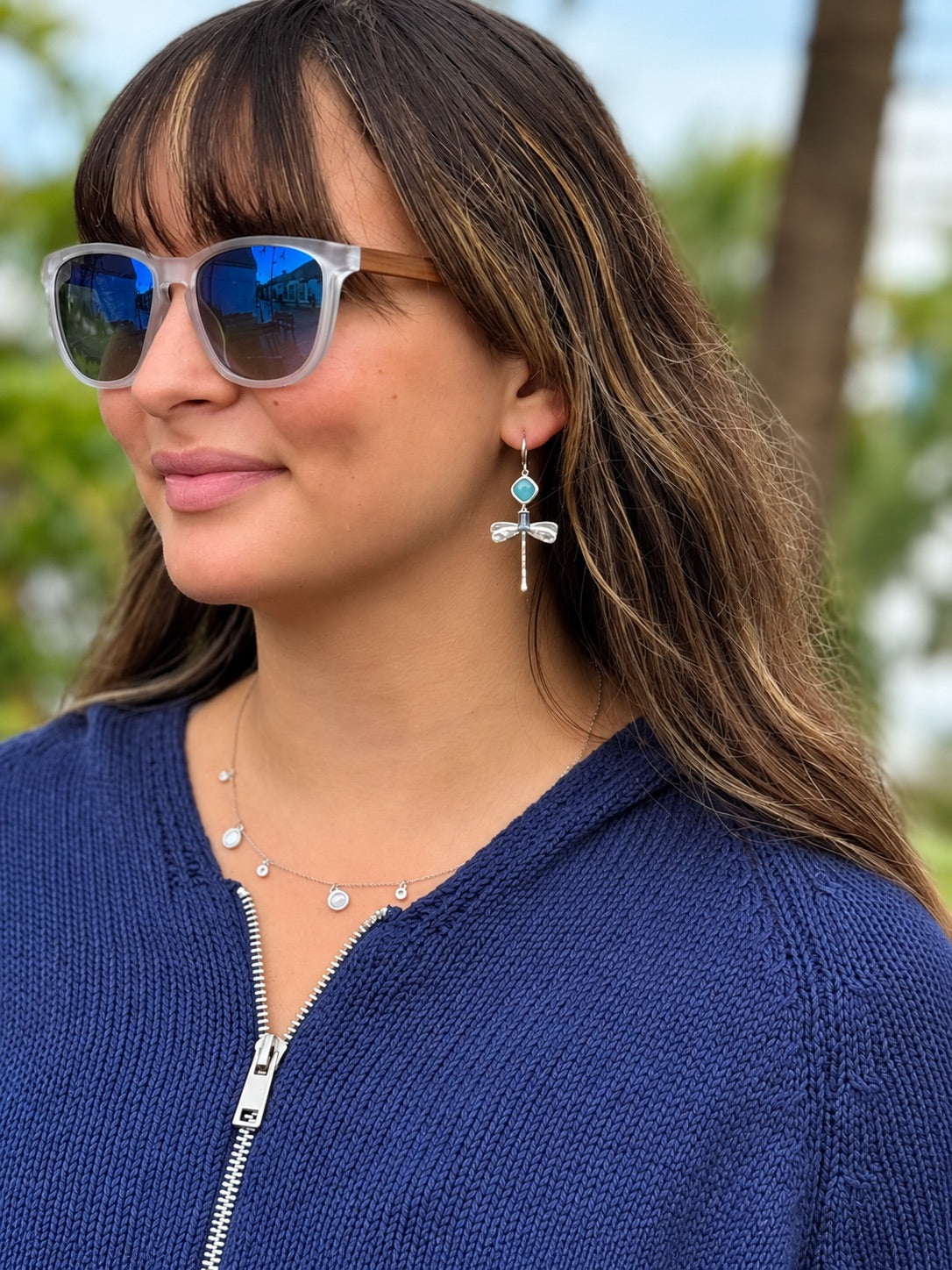 Lila Dragonfly Earrings in Silver displayed on a white background, featuring turquoise-blue faceted stones, deep blue accents, textured silver dragonflies, and fishhook closures.
