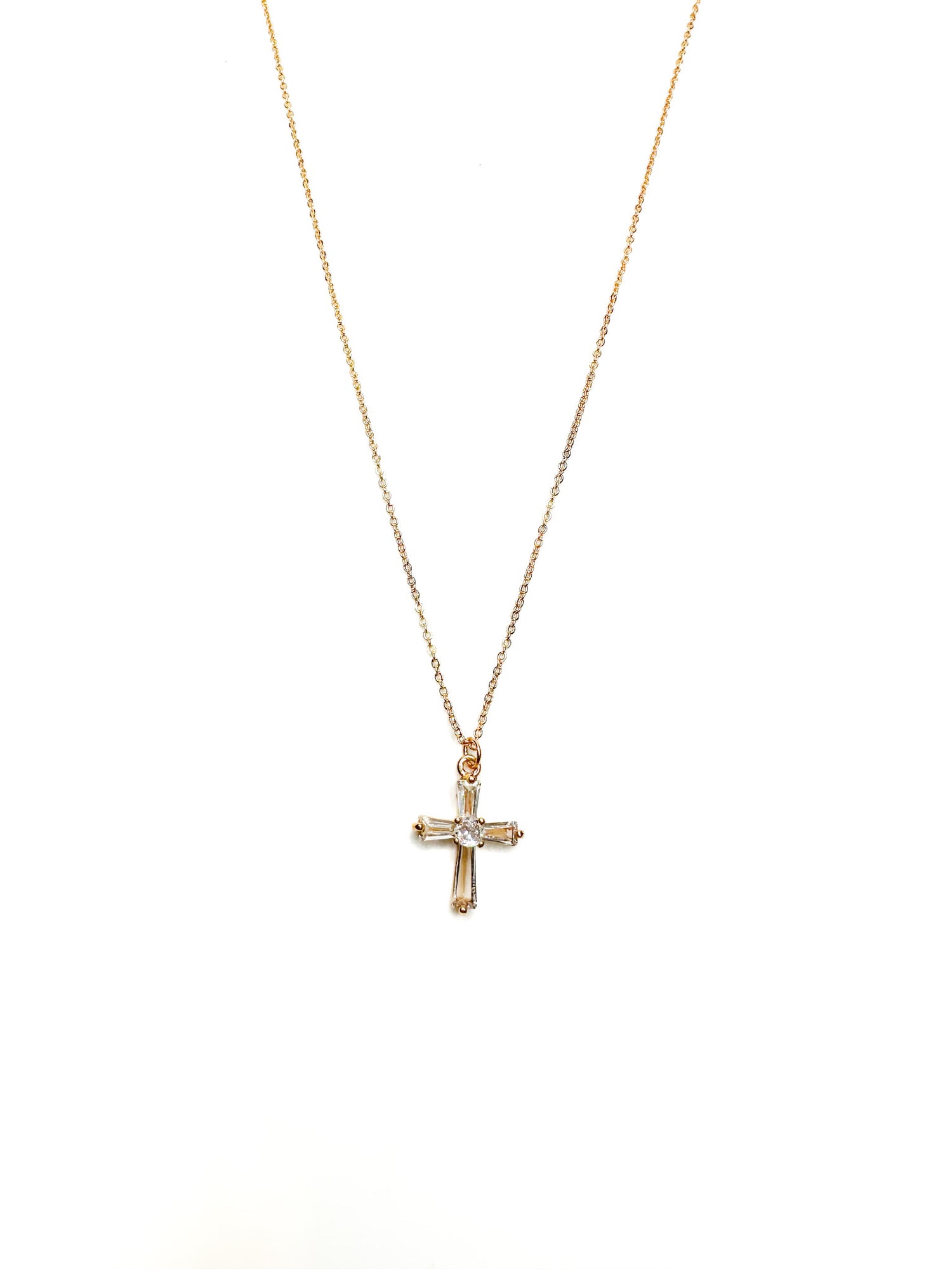 Gold cross necklace on a white background