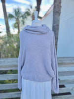 Soft grey fuzzy knit sweater with a cowl neck on a mannequin outdoors with a white skirt