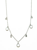 Melody Silver Necklace featuring a delicate silver-tone chain with five round white mother-of-pearl inspired charms and four smaller sparkling crystal accents.