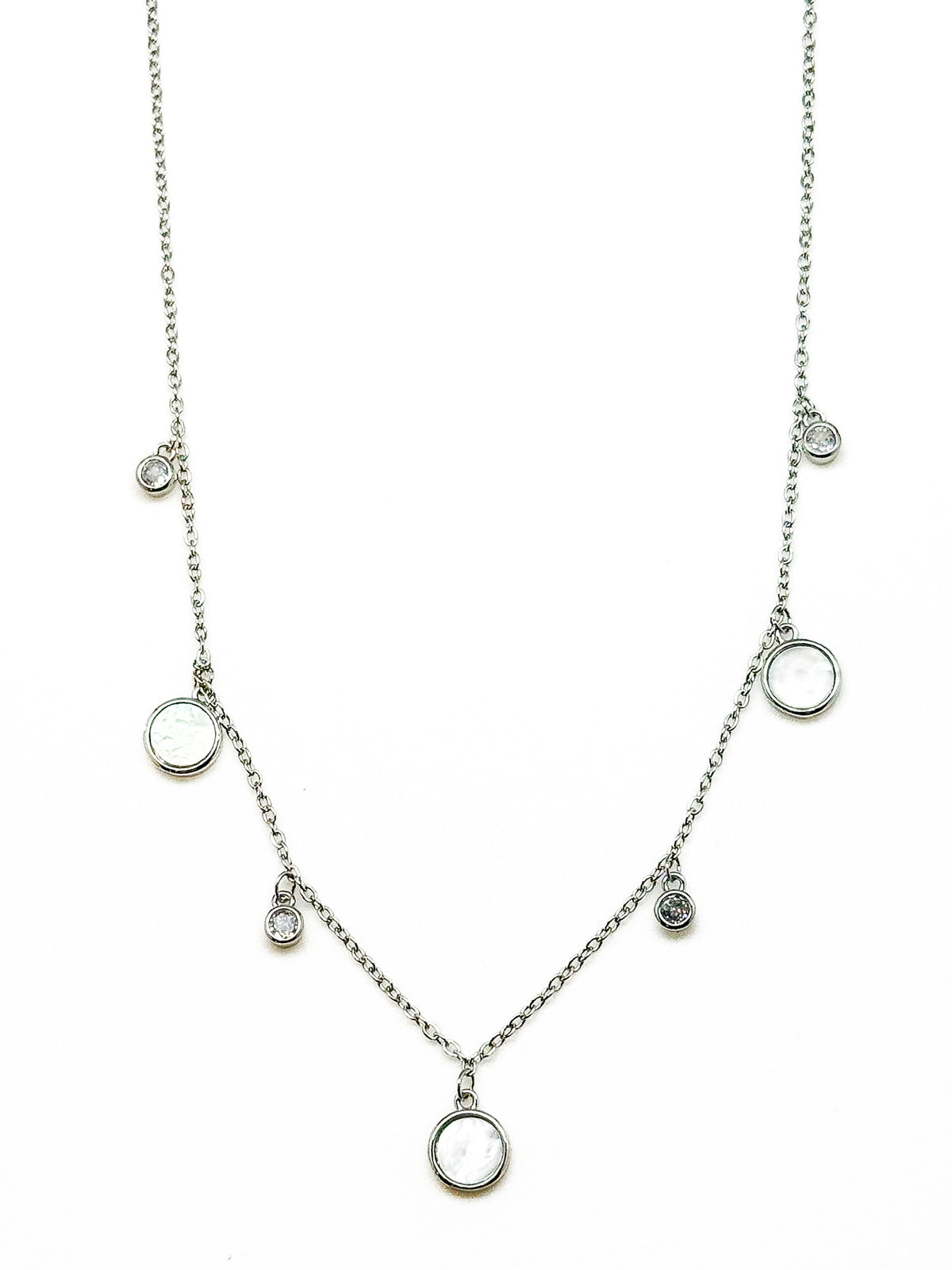 Melody Silver Necklace featuring a delicate silver-tone chain with five round white mother-of-pearl inspired charms and four smaller sparkling crystal accents.