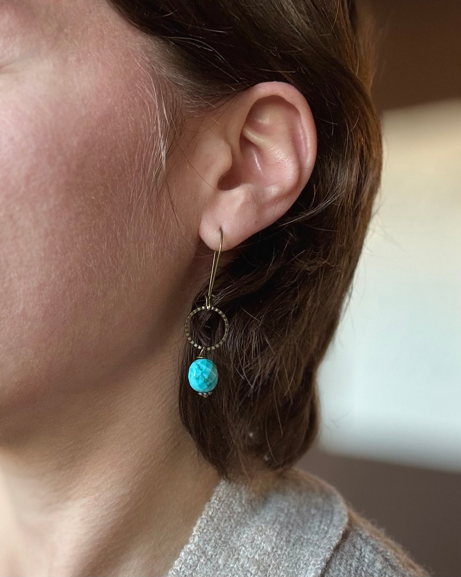 Model wearing Ocean Jasper brass dangle earrings by Nina Halls