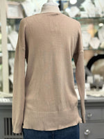 Back view of a soft blush taupe sweater with a relaxed silhouette, drop shoulder sleeves, and wide ribbed hemline.