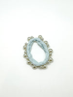 Marble-patterned earring with pearl-like beads on a white background