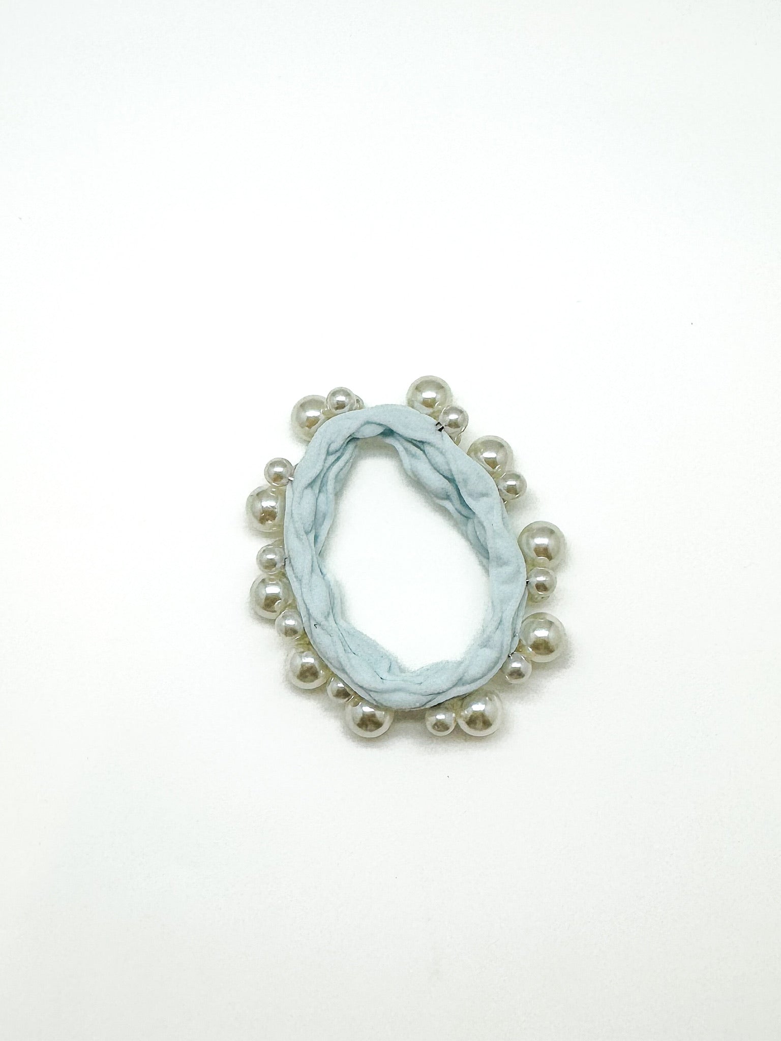 Marble-patterned earring with pearl-like beads on a white background