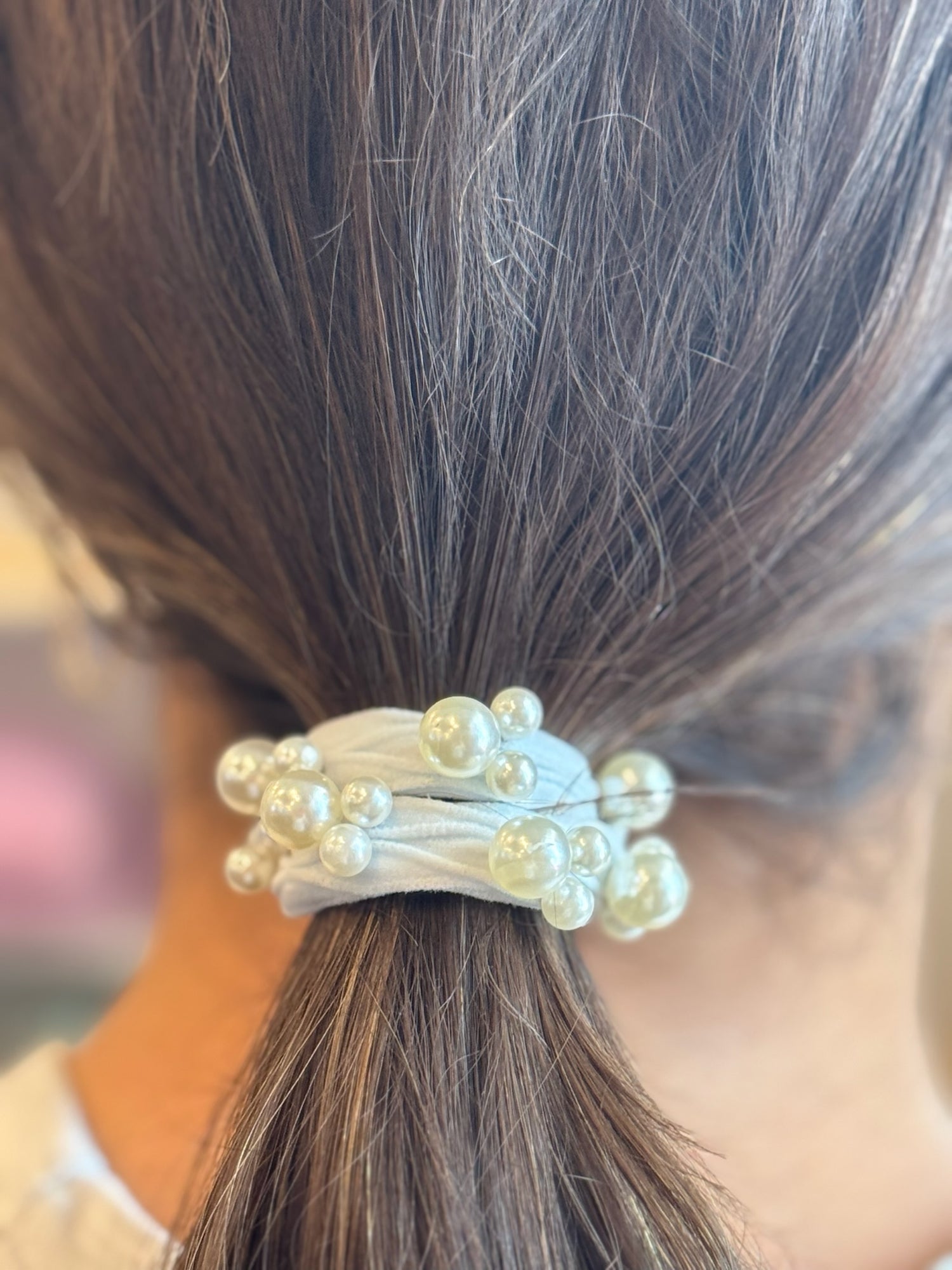 Hair tie with pearls wrapped around a ponytail