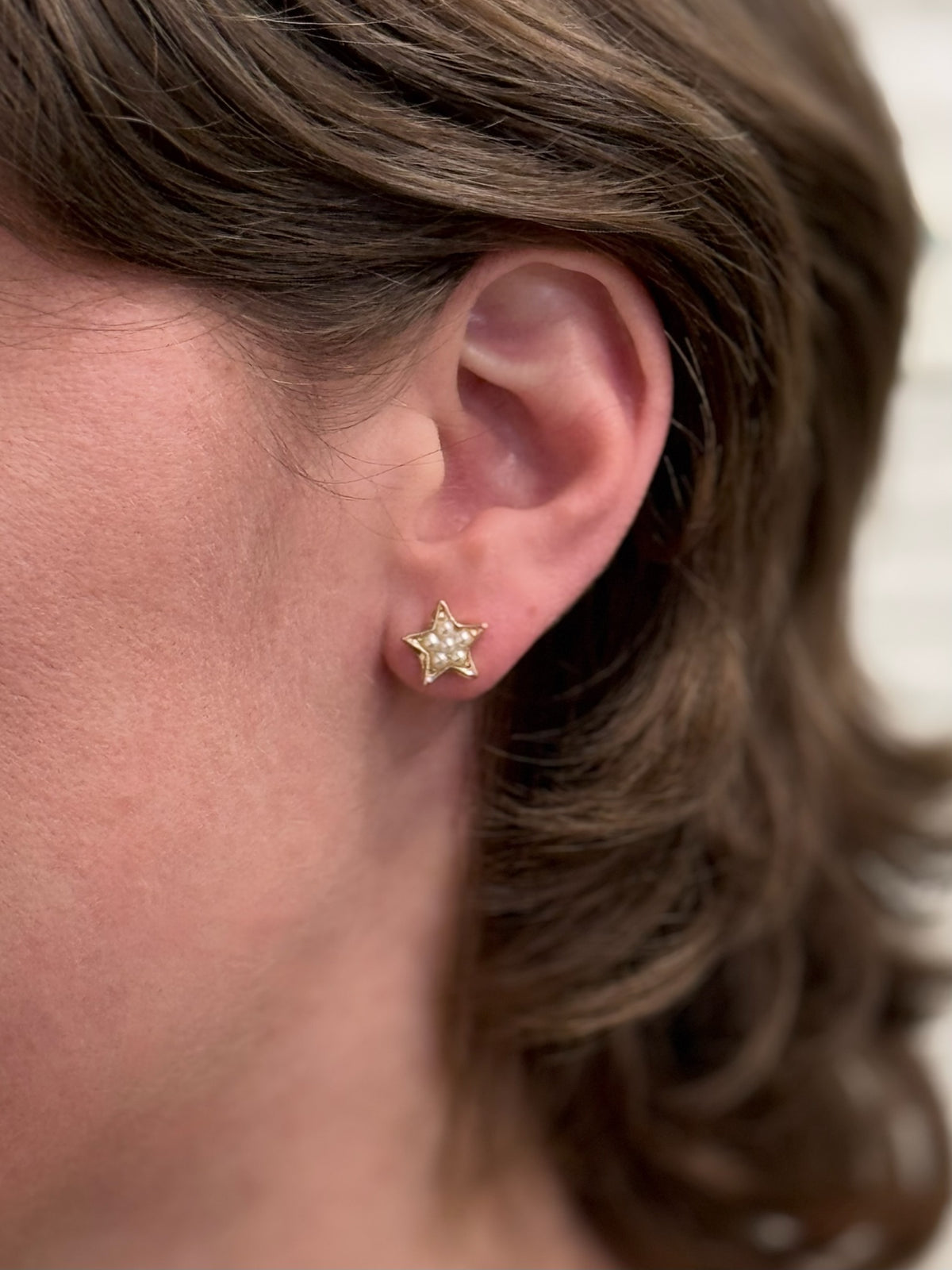 Gold pearl starfish studs being worn