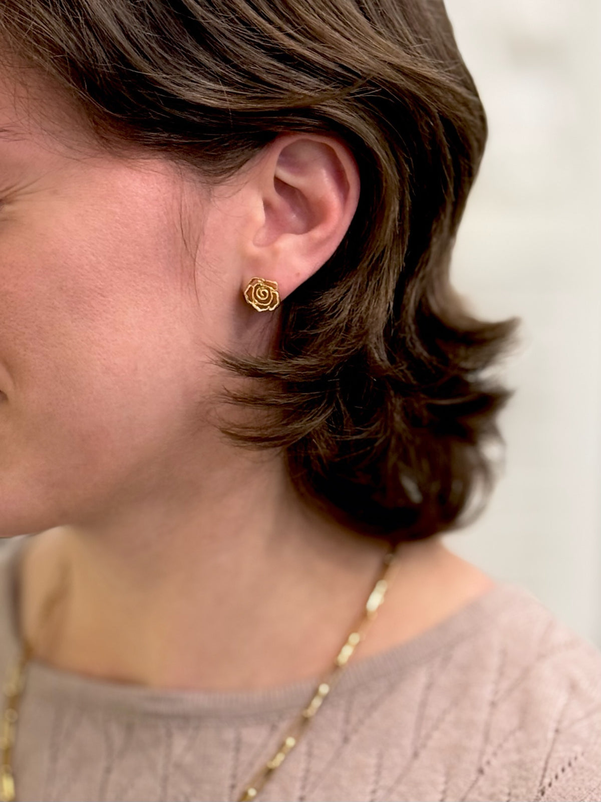 Gold rose studs being worn