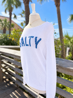 Side view of the white SALTY beach sweater featuring blue lettering, breathable knit texture, long sleeves, and a relaxed fit at Ardor Boutique.