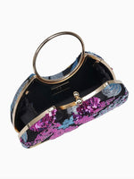 A structured evening clutch bag with a circular gold-tone handle, gold-tone metal frame, and a black base covered in pink, purple, and blue sequins, shown open against a plain white background.