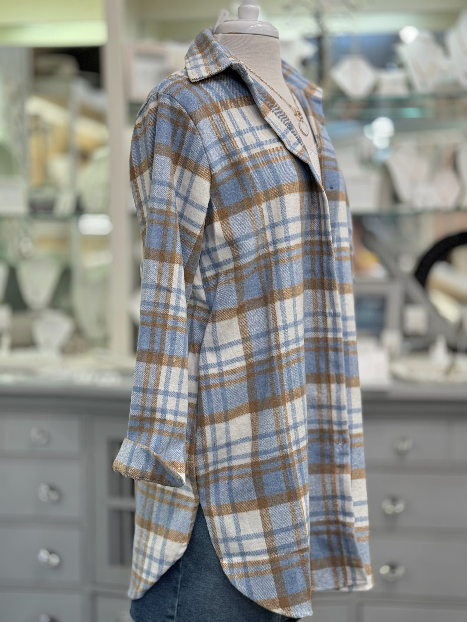Side view of women’s layering shacket in blue and tan plaid pattern.
