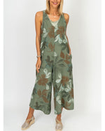 Model wearing the Sienna Leaf Print Romper in Olive with wide legs and floral print