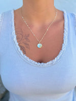 18k gold-filled chain with a radiant mother-of-pearl sun pendant being worn