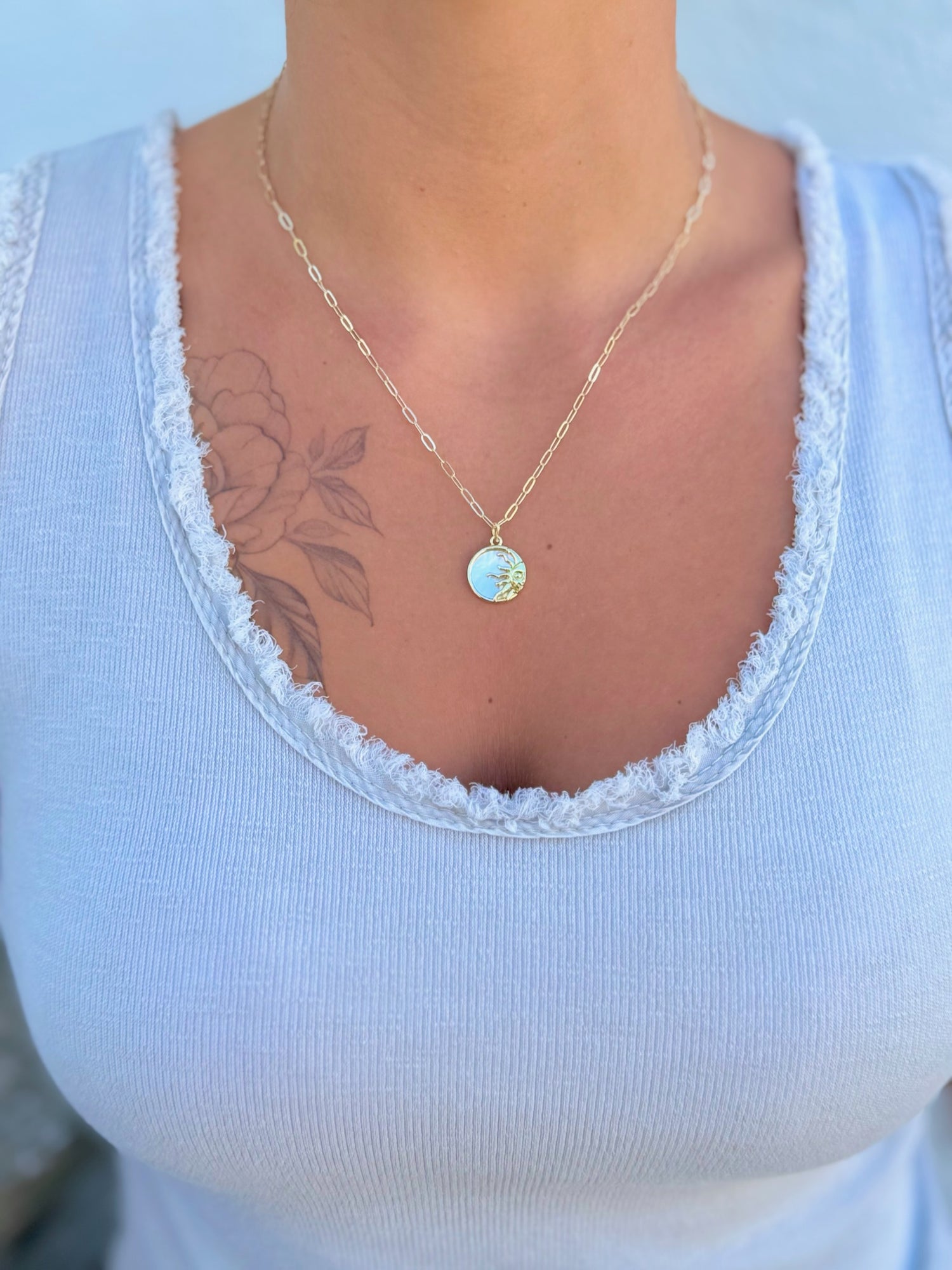 18k gold-filled chain with a radiant mother-of-pearl sun pendant being worn