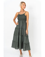 Woman wearing a green tiered dress on a white background