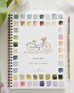 Spring watercolor workbook by Emily Lex with spiral binding and bicycle illustration on the cover surrounded by watercolor swatches