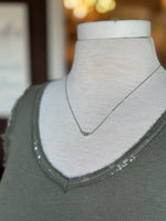Close-up of the Stacey Necklace in silver with three crystal accents styled with an olive green tank at Ardor Boutique.