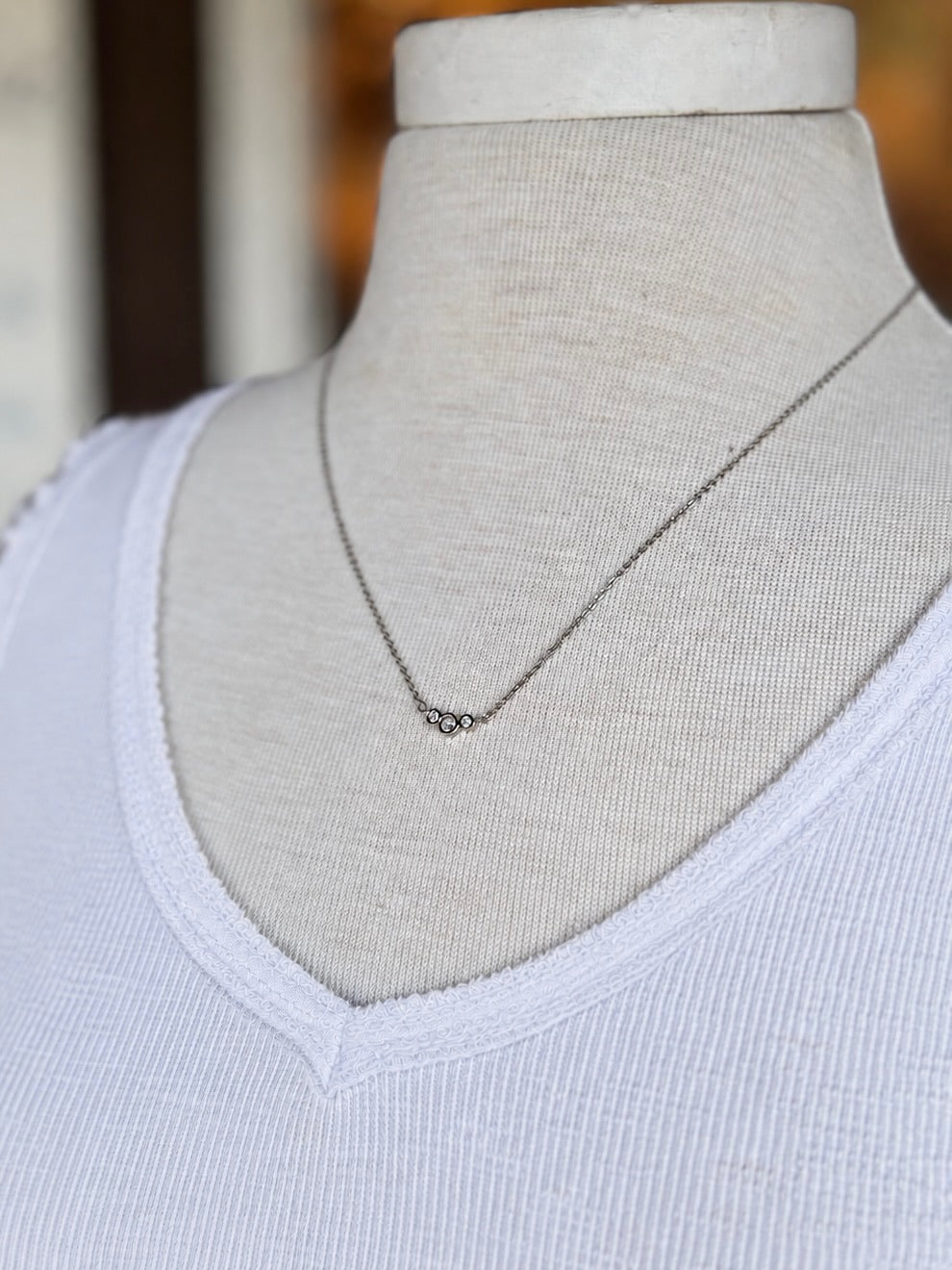 Stacey Necklace in silver styled with a white tank, showing its delicate three-crystal design and subtle sparkle at Ardor Boutique.