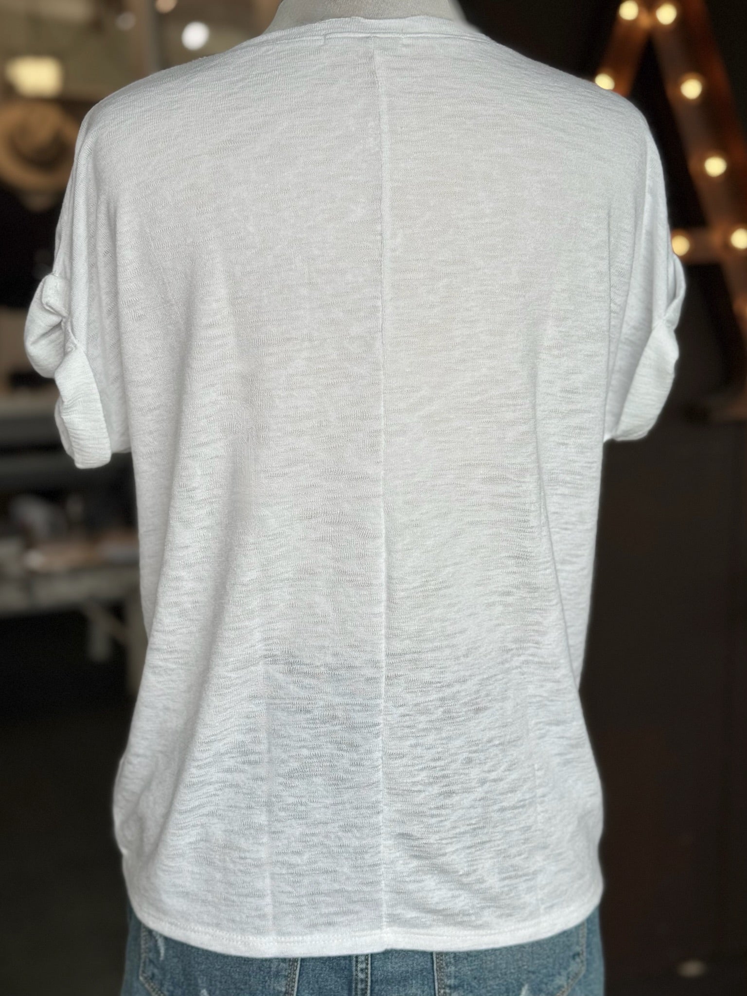 Back view of the white Terri V Neck Tee showing its relaxed silhouette, lightweight fabric, cuffed short sleeves, and center back seam at Ardor Boutique.