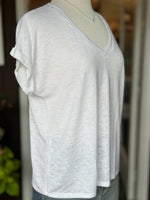 Side view of the Terri V Neck Tee in white highlighting the relaxed drape, V neckline, and cuffed short sleeve detail at Ardor Boutique.