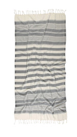 A striped beach towel in gray and white, with fringed edges.