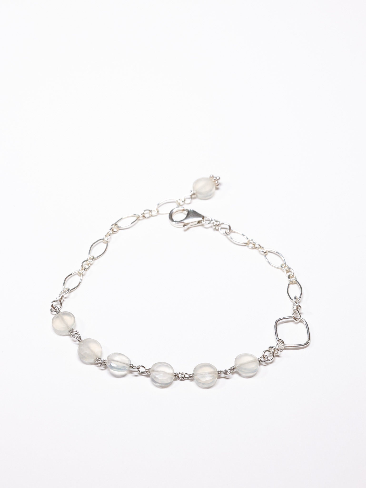 A sterling silver bracelet with moonstone beads and a lobster clasp, displayed against a white background.