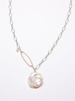 Handcrafted necklace featuring a large white Keshi freshwater pearl pendant on a sterling silver chain with a hammered rose gold oval accent and small pearl detail. Limited edition Nina Halls design, exclusive to Ardor Boutique.