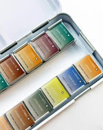 Set of watercolor pans in various colors on a white background