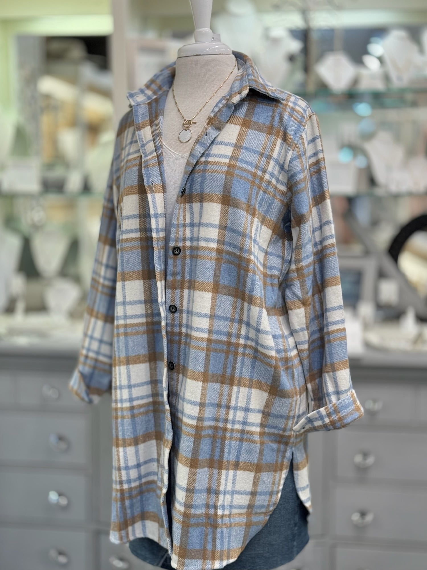 Women’s blue and camel plaid button-down shacket with longline fit.