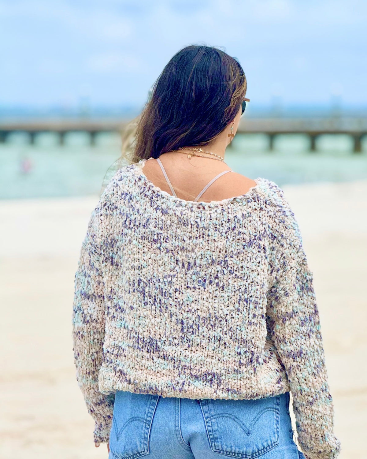 Back view of the Annie blue-grey multicolor knit sweater showing its textured knit, wide neckline and long sleeves.