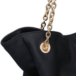 Black handbag with a gold chain and clasp on a white background