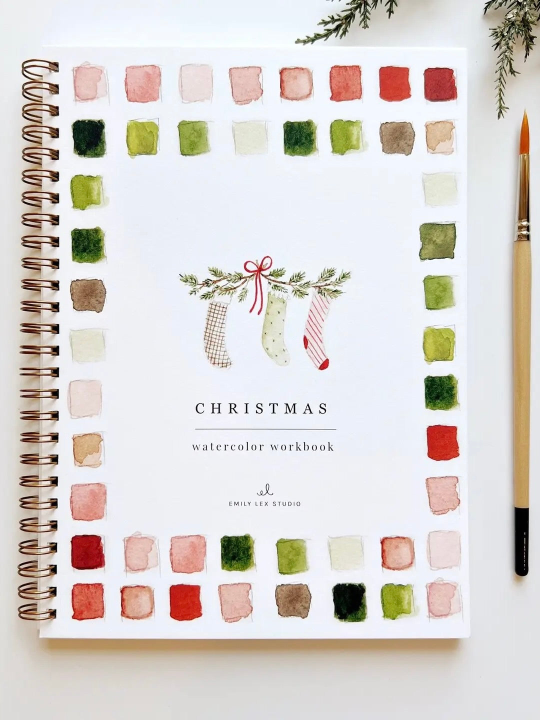 Christmas Watercolor Workbook front cover with watercolor stockings and color palette border, spiral bound by Emily Lex